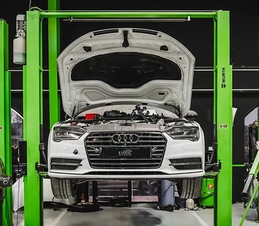White Audi raised on the ramp at the Exotic Auto Services workshop in Musaffah
