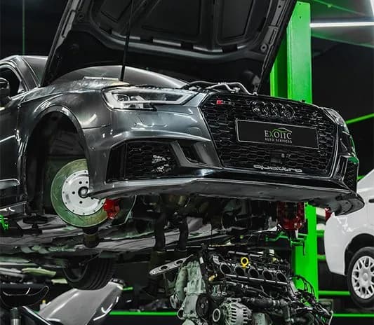 Audi with the engine lifted out during major mechanical work at the Exotic Auto Services workshop